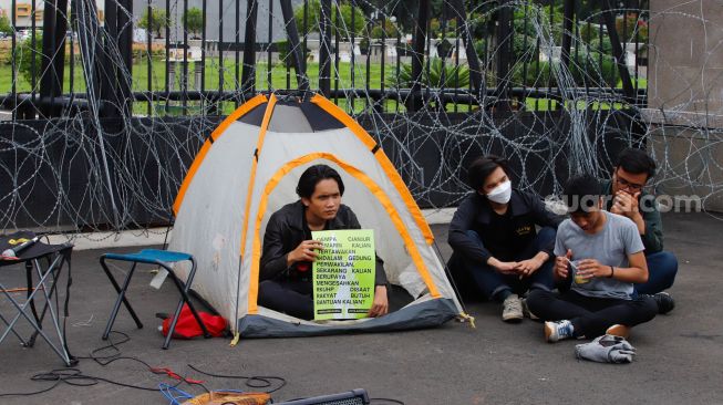 Massa saat menggelar aksi unjuk rasa menolak pengesahan KUHP di depan Gedung DPR RI, Senayan, Jakarta Pusat, Selasa (6/12/2022). [Suara.com/Alfian Winanto]