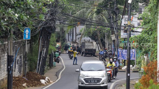 Instalasi kabel yang semrawut terlihat di Jalan Kemang Utara, Mampang Prapatan, Jakarta Selatan, Rabu (7/12/2022). [Suara.com/Alfian Winanto]