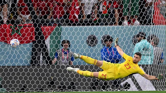 Kiper Spanyol Unai Simon tak mampu menghalau tembakan gelandang Maroko Hakim Ziyech dalam babak adu penalti dalam pertandingan sepak bola babak 16 besar Piala Dunia Qatar antara Maroko dan Spanyol di Education City Stadium di Al-Rayyan, barat Doha, Qatar, Selasa (6/12/2022). [Kirill KUDRYAVTSEV / AFP]
