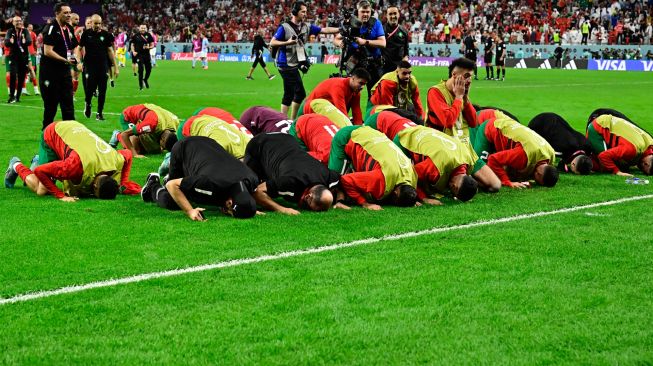 Para pemain Maroko bersujud setelah memenangkan pertandingan sepak bola babak 16 besar Piala Dunia Qatar antara Maroko dan Spanyol di Education City Stadium di Al-Rayyan, barat Doha, Qatar, Selasa (6/12/2022). [JAVIER SORIANO / AFP]