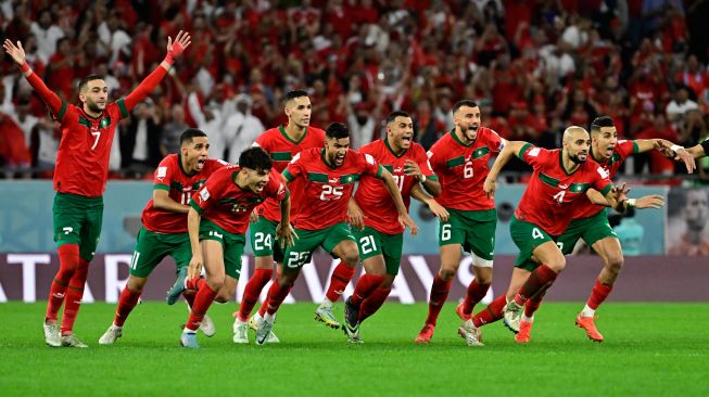 Maroko merayakan kemenangan mereka dalam babak adu penalti saat pertandingan sepak bola babak 16 besar Piala Dunia Qatar antara Maroko dan Spanyol di Education City Stadium di Al-Rayyan, barat Doha, Qatar, Selasa (6/12/2022).[JAVIER SORIANO / AFP]