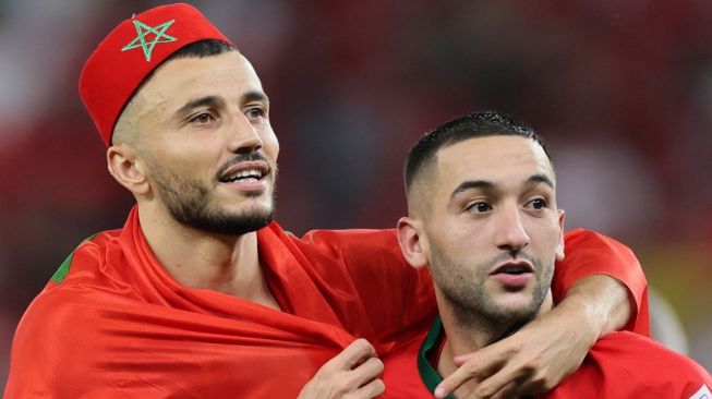 Winger Timnas Maroko, Hakim Ziyech (kanan) dan kapten Romain Saiss di Piala Dunia 2022. [KARIM JAAFAR / AFP]