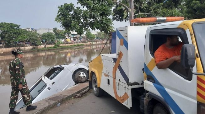 Tabrak Motor yang Terparkir, Mobil Grand Max Nyemplung ke Kali Cengkareng Drain