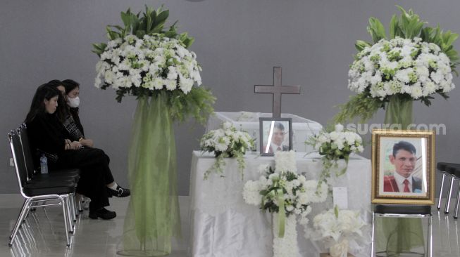 Keluarga Marsha Aruan duduk disamping jenazah Ayahnya di Rumah Duka, RS Ukrida, Jakarta, Kamis (8/12). [Suara.com/Oke Atmaja]