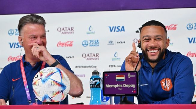 Pelatih Timnas Belanda Louis Van Gaal (Kiri) dan penyerang Belanda Memphis Depay (Kanan) berbagi lelucon saat mereka menghadiri konferensi pers di Pusat Konvensi Nasional Qatar (QNCC) di Doha pada 8 Desember 2022, menjelang laga perempat final Piala Dunia 2022 antara Belanda vs Argentina.Alberto PIZZOLI / AFP.