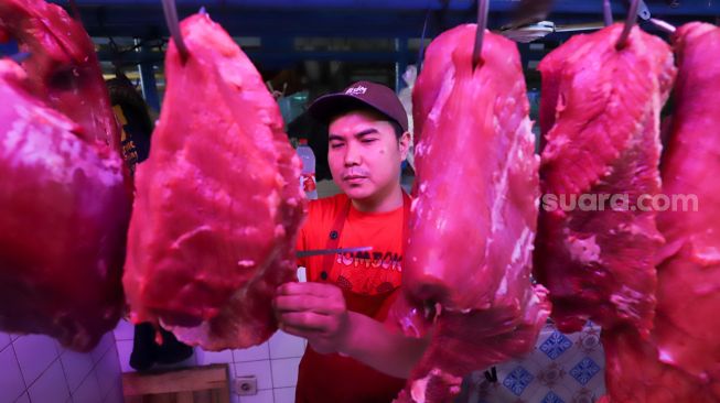 Pedagang memilih daging sapi untuk pembei di Pasar Santa, Jakarta Selatan, Jumat (9/12/2022). [Suara.com/Alfian Winanto]