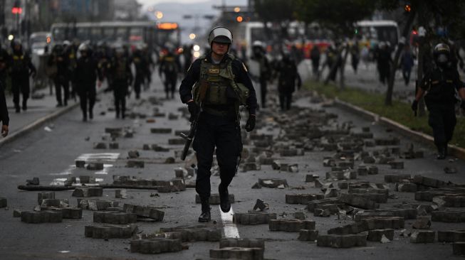 Anggota Polisi terlihat saat bentrok dengan pendukung mantan Presiden Peru Pedro Castillo di pinggiran Prefektur Lima tempat Castillo ditahan, di Lima, Peru, Rabu (7/12/2022). [ERNESTO BENAVIDES / AFP]
