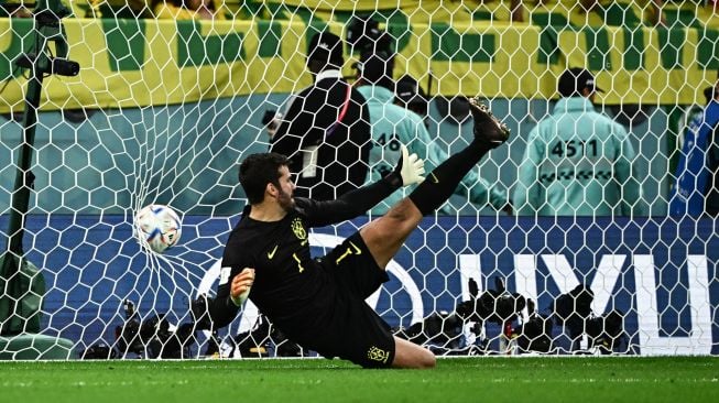 Gelandang Kroasia Lovro Majer mencetak gol melewati kiper Brazil Alisson dalam babak adu penalti saat pertandingan sepak bola perempat final Piala Dunia 2022 antara Kroasia dan Brazil di Stadion Education City di Al-Rayyan, barat Doha, Qatar, Jumat (9/12/2022). [Jewel SAMAD/AFP]