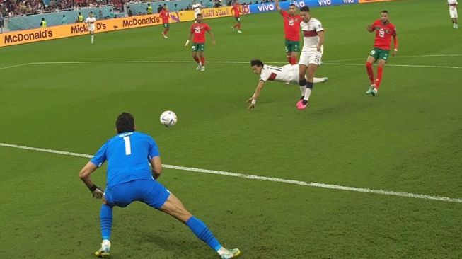 Pemain Portugal Joao Felix menyundul bola ke arah gawang Maroko dalam pertandingan perempat final Piala Dunia 2022 di Al Thumama Stadium, Sabtu (10/12/2022). [AFP]