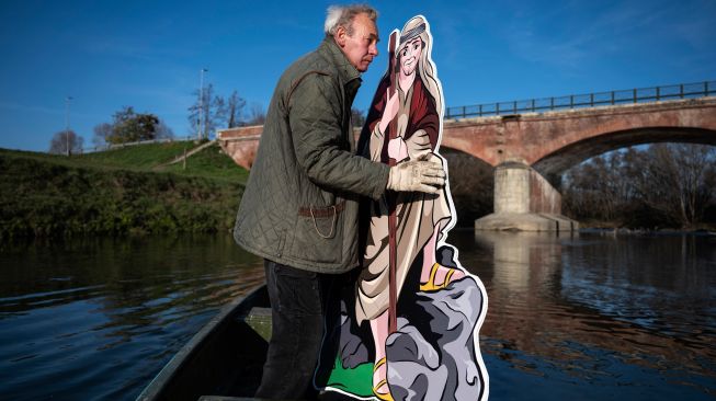 Warga saat akan memasang Instalasi Natal yang berkisah tentang kelahiran Yesus di sungai Po, Villafranca Piemonte, Turin, Italia, Selasa (6/12/2022). [MARCO BERTORELLO / AFP]
