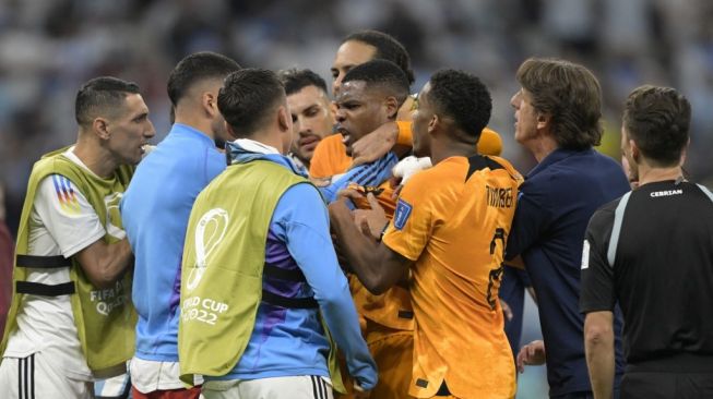 Bek Timnas Belanda #22 Denzel Dumfries (tengah) ditenangkan oleh rekan setimnya selama pertandingan perempat final Piala Dunia 2022 antara Belanda vs Argentina di Stadion Lusail, utara Doha pada Sabtu (10/12/2022) dini hari WIB.JUAN MABROMATA/AFP