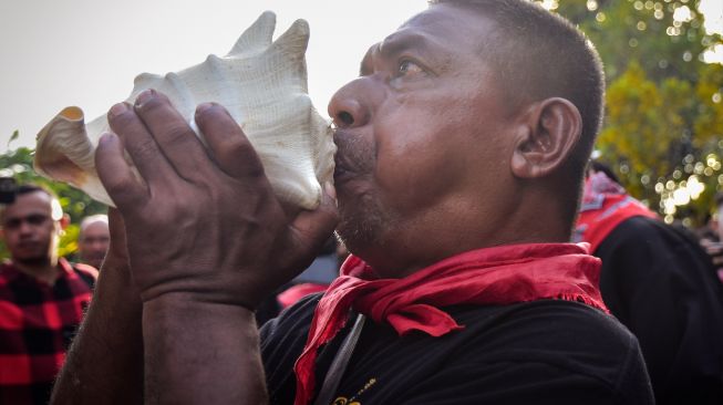 Seorang warga meniup alat musik tahuri saat puncak tradisi Cuci Negeri di Negeri (Desa) Soya, Kota Ambon, Provinsi Maluku, Jumat (9/12/2022). [ANTARA FOTO/FB Anggoro/nz]
