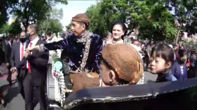 Presiden Jokowi dan Ibu Negara Iriana saat menaiki kereta kuda pada kirab ngunduh mantu Kaesang dan Erina di Kota Solo. [YouTube/Presiden Joko Widodo]