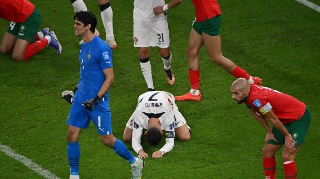 Pemain Portugal Critiano Ronaldo menangis usai timnya disingkirkan Maroko di babak perempat final Piala Dunia 2022. Laga yang digelar di Al Thumama Stadium, Sabtu (10/12/2022) berakhir dengan skor 1-0 untuk Maroko. [AFP]