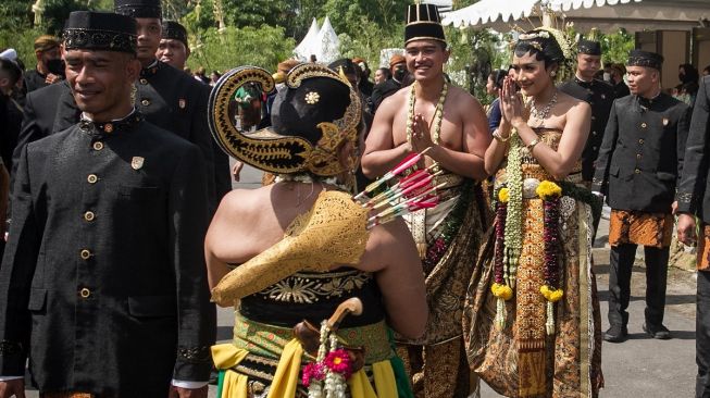 Pengantin yang juga putra bungsu Presiden Joko Widodo Kaesang Pangarep (ketiga kanan) dengan Erina Gudono (kedua kanan) berjalan masuk Pura Mangkunegaran untuk mengikuti acara Tasyakuran pernikahan di Solo, Jawa Tengah, Minggu (11/12/2022). [ANTARA FOTO/Mohammad Ayudha].