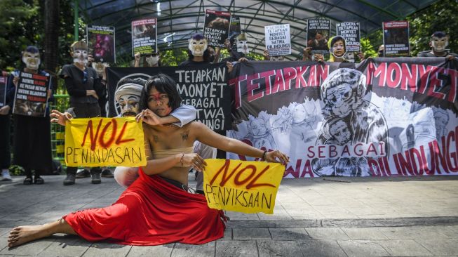 Pengunjuk rasa yang tergabung dalam Koalisi Primates Fight Back menggelar aksi teatrikal di depan Kantor Kementerian LHK, Jakarta, Senin (12/12/2022). Mereka mendesak pemerintah segera menetapkan monyet sebagai satwa dilindungi. [ANTARA FOTO/Galih Pradipta].