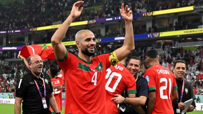 Gestur gelandang Maroko Sofyan Amrabat usai timnya mengalahkan Portugal di perempat final Piala Dunia 2022 yang digelar di Al Thumama Stadium, Sabtu (10/12/2022). [AFP]