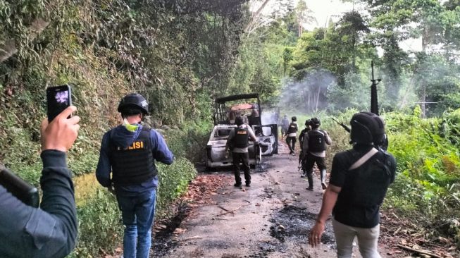 Aparat kepolisian saat tiba di lokasi tempat mobil polisi dibakar oleh TPNPB-OPM di KM 1 Jalan Trans Yapen Saubeba-Angkaisera, Papua, pada Selasa (13/12) sekitar pukul 12.20 WIT. [Foto dok. Ist]