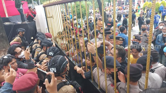 Sejumlah orang yang mengatasnamakan kader Partai Prima melakukan aksi unjuk rasa di depan Kantor KPU RI dan sempat saling dorong dengan Polisi, Rabu (14/12/2022). [Suara.com/Bagaskara)