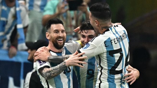 Penyerang timnas Argentina #09 Julian Alvarez (Tengah) melakukan selebrasi dengan #10 Lionel Messi dan #24 Enzo Fernandez setelah mencetak gol kedua timnya selama pertandingan semifinal Piala Dunia 2022 antara Argentina vs Kroasia di Stadion Lusail di Lusail, utara Doha pada Rabu (14/12/2022) dini hari WIB.Anne-Christine POUJOULAT / AFP