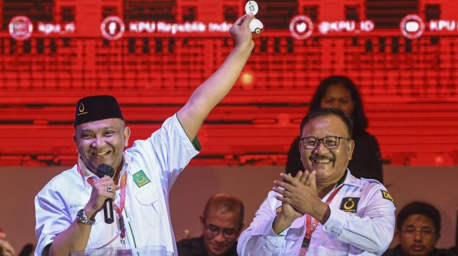 Sekjen Partai Bulan Bintang Afriansyah Noor (kiri) menunjukkan nomor urut 13 saat penetapan nomor urut partai politik peserta Pemilu 2024 di Halaman KPU, Jakarta, Rabu (14/12/2022). [ANTARA FOTO/Galih Pradipta].