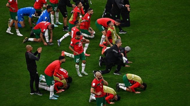 Pemain timnas Maroko bertepuk tangan dan sujud syukur setelah dikalahkan Prancis dalam pertandingan semifinal Piala Dunia 2022 Qatar antara Prancis vs Maroko di Stadion Al-Bayt di Al Khor, utara Doha pada Kamis (15/12/2022) dini hari WIB.Anne-Christine POUJOULAT / AFP.