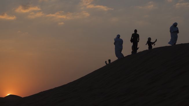 Wisatawan menyaksikan matahari tenggelam saat berwisata gurun pasir di Dubai, Uni Emirat Arab, Kamis (15/12/2022). .ANTARA FOTO/Wahyu Putro