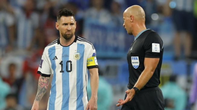 Penyerang Timnas Argentina #10 Lionel Messi berbicara dengan wasit Polandia Szymon Marciniak selama pertandingan babak 16 besar Piala Dunia 2022 antara Argentina vs Australia di Stadion Ahmad Bin Ali di Al-Rayyan, barat Doha pada 3 Desember 2022.Aneh ANDERSEN / AFP.