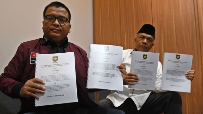 Ketua Tim Advokasi Hukum Partai Ummat Denny Indrayana (kiri) dan Wakil Ketua Tim Advokasi Hukum Partai Ummat Herman Kadir (kanan) menunjukkan berkas permohonan penyelesaian sengketa proses Pemilu 2024 ke petugas Bawaslu di Jakarta, Jumat (16/12/2022).  ANTARA FOTO/Aditya Pradana Putra