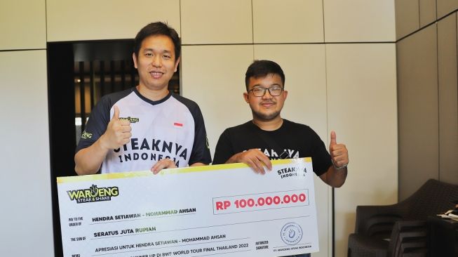 Pebulu tangkis nasional, Hendra Setiawan saat diberikan bonus dari sponsor secara simbolis pasca menjadi runner-up BWF World Tour Finals 2022. [Istimewa]