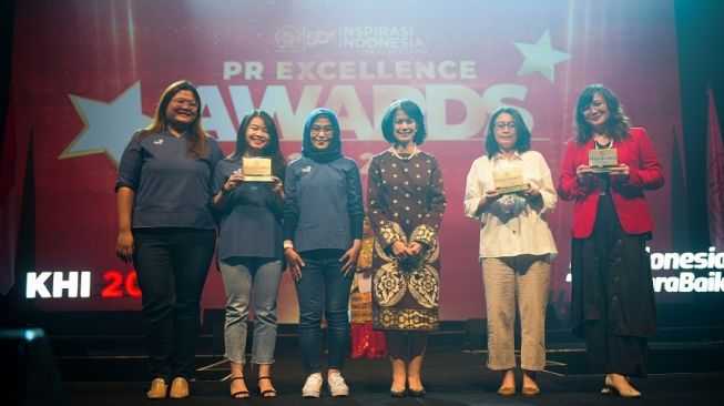 Sejumlah perwakilan Peace Mate tim penyelenggara HUT 66 Grow & Glow Asuransi Astra saat menerima penghargaan PERHUMAS PR Excellence Awards 2022 kategori Internal PR Program yang diberikan langsung oleh Head School of Communication, Atma Jaya Catholic University, Prof. Dr. Dorien Kartikawangi [Asuransi Astra].