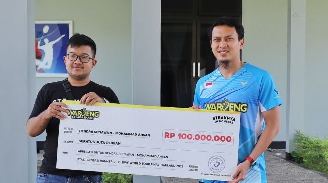 Pebulu tangkis nasional, Mohammad Ahsan saat diberikan bonus dari sponsor secara simbolis pasca menjadi runner-up BWF World Tour Finals 2022. [Istimewa]