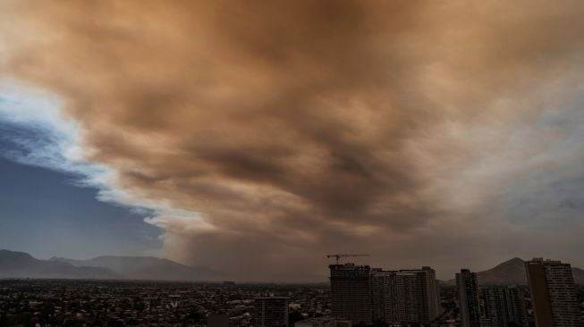 Pemandangan kota yang diselimuti asap dari kebakaran hutan yang melanda daerah sekitarnya di Santiago, Chili, Jumat (16/12/2022). [JAVIER TORRES / AFP]