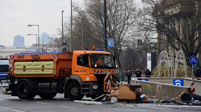 Kendaraan departemen kebersihan kota membersihkan jalan dari puing-puing di depan hotel Radisson Blu, tempat akuarium besar yang terletak di lobi hotel meledak di Berlin, Jerman, Jumat (16/12/2022). [John MACDOUGALL / AFP]