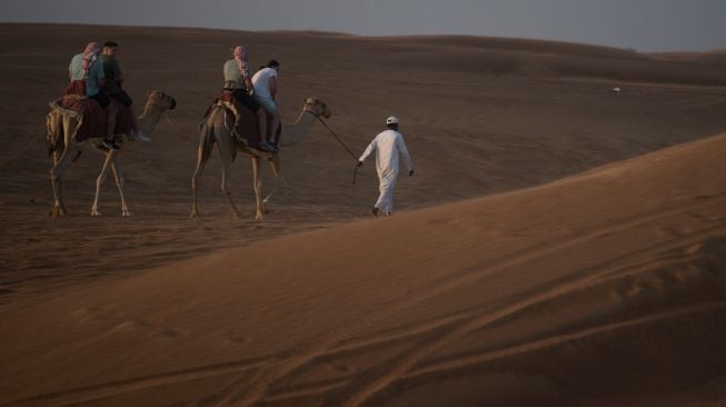 Wisatawan menaiki Unta saat berwisata gurun pasir di Dubai, Uni Emirat Arab, Kamis (15/12/2022). [ANTARA FOTO/Wahyu Putro A/YU]