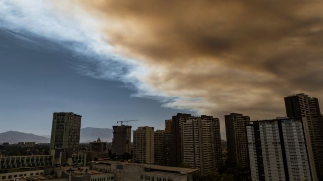 Pemandangan kota yang diselimuti asap dari kebakaran hutan yang melanda daerah sekitarnya di Santiago, Chili, Jumat (16/12/2022). [JAVIER TORRES / AFP]