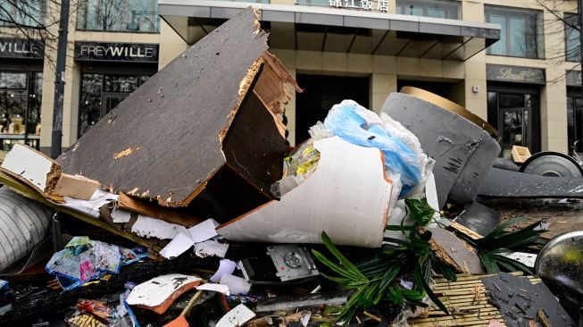 Puing-puing berserakan di depan hotel Radisson Blu, tempat akuarium besar yang terletak di lobi hotel meledak di Berlin, Jerman, Jumat (16/12/2022). [John MACDOUGALL / AFP]