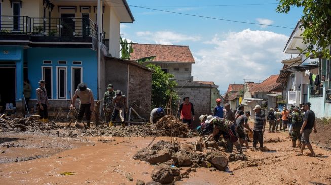 Warga membersihkan puing akibat banjir bandang di Sawahdadap, Cimanggung, Kabupaten Sumedang, Jawa Barat, Minggu (18/12/2022). [ANTARA FOTO/Ahmad Fauzan].