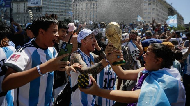 Fans Argentina berkumpul di Tugu Obelisk untuk merayakan kemenangan Piala Dunia Qatar 2022 melawan Prancis di Buenos Aires, Argentina, Minggu (18/12/2022). [Emiliano Lasalvia / AFP]