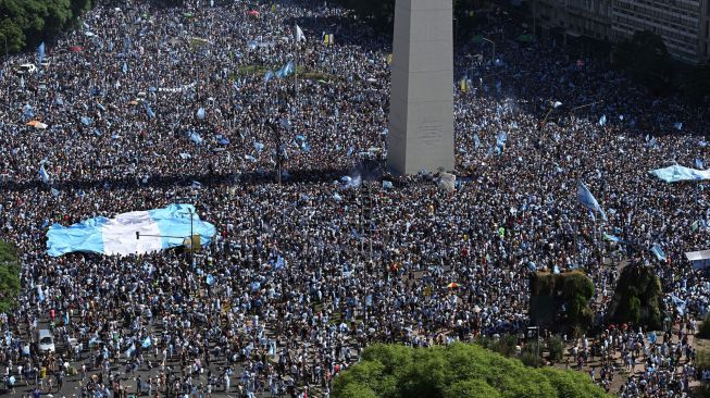 Fans Argentina berkumpul di Tugu Obelisk untuk merayakan kemenangan Piala Dunia Qatar 2022 melawan Prancis di Buenos Aires, Argentina, Minggu (18/12/2022). [Emiliano Lasalvia / AFP]