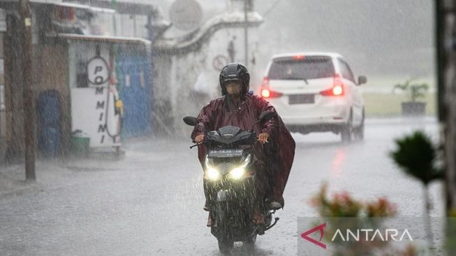 Pengendara sepeda motor menggunakan mantel saat hujan di kawasan Alun-alun Selatan, Yogyakarta, Selasa (8/11/2022). BMKG mengeluarkan peringatan dini potensi cuaca ekstrem di wilayah Daerah Istimewa Yogyakarta (DIY) berlaku tanggal 8-10 November 2022 dengan potensi curah hujan intensitas sedang-lebat yang dapat disertai kilat/petir menyusul adanya peningkatkan potensi pertumbuhan awan hujan di beberapa wilayah D.I Yogyakarta. ANTARA FOTO/Andreas Fitri Atmoko/TOM. [Antara Foto/Andreas Fitri Atmoko]