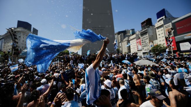 Fans Argentina berkumpul di Tugu Obelisk untuk merayakan kemenangan Piala Dunia Qatar 2022 melawan Prancis di Buenos Aires, Argentina, Minggu (18/12/2022). [Emiliano Lasalvia / AFP]