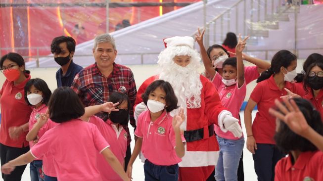 Keseruan Ferry Irianto, General Manager Mal Ciputra Jakarta bersama Santa Claus dan anak-anak Panti Asuhan Vincentius Puteri main salju pada Senin (12/12/2022).