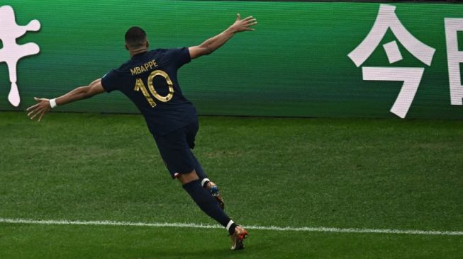 Penyerang Timnas Prancis, Kylian Mbappe melakukan selebrasi usai mencetak gol ke gawang Argentina pada babak perpanjangan waktu laga final Piala Dunia 2022 di Qatar, Senin (19/12/2022) dini hari WIB. [Jewel SAMAD / AFP]