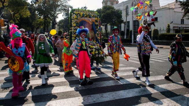 Para badut memainkan musik saat mengikuti prosesi penghormatan kepada santo pelindung Meksiko, Our Lady of Guadalupe, di Mexico City, Meksiko, Senin (19/12/2022). [CLAUDIO CRUZ/AFP]