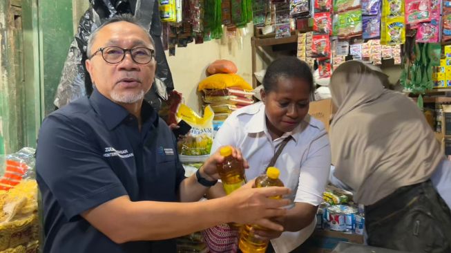 Menteri Perdagangan Zulkifli Hasan membeli minyak dengan pedagang saat mengunjungi Pasar Sentral Remu di Kota Sorong, Papua Barat, Rabu (21/12).  [Dok Kemendag]