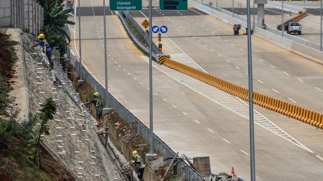 Pekerja menyelesaikan pembangunan Jalan Tol Cijago seksi 3A di Krukut, Depok, Jawa Barat, Rabu (21/12/2022). [ANTARA FOTO/Asprilla Dwi Adha].