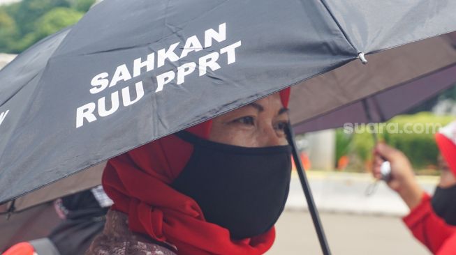 Sejumlah Ibu Pekerja Rumah Tangga (PRT) melakukan aksi Rabuan PRT: Payung Duka Seribu Ibu-Ibu PRT Indonesia di Taman Aspirasi Monas, Jakarta Pusat, Rabu (21/12/2022). [Suara.com/Alfian Winanto]