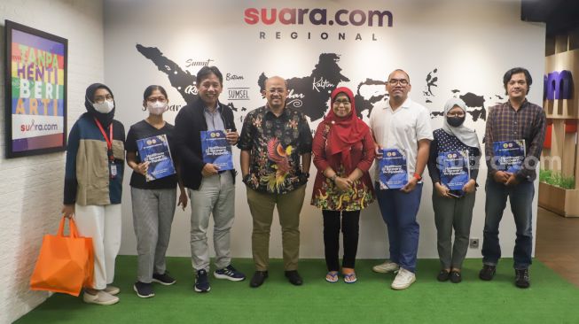 Ketua Umum PB IDI Adib Khumaidi bersama Wakil Bendahara Umum PB IDI Asturi Putri foto bersama dengan Pemimpin Redaksi Suara.com Suwarjono beserta beberapa karyawan di Kantor Suara.com, kawasan Kuningan, Jakarta Selatan, Rabu (21/12/2022). [Suara.com/Alfian Winanto].