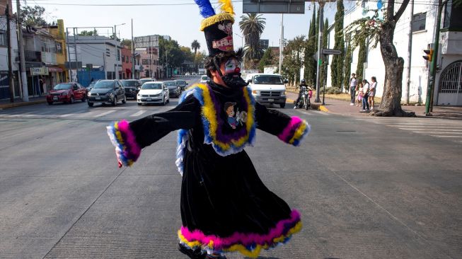 Para badut memainkan musik saat mengikuti prosesi penghormatan kepada santo pelindung Meksiko, Our Lady of Guadalupe, di Mexico City, Meksiko, Senin (19/12/2022). [CLAUDIO CRUZ/AFP]